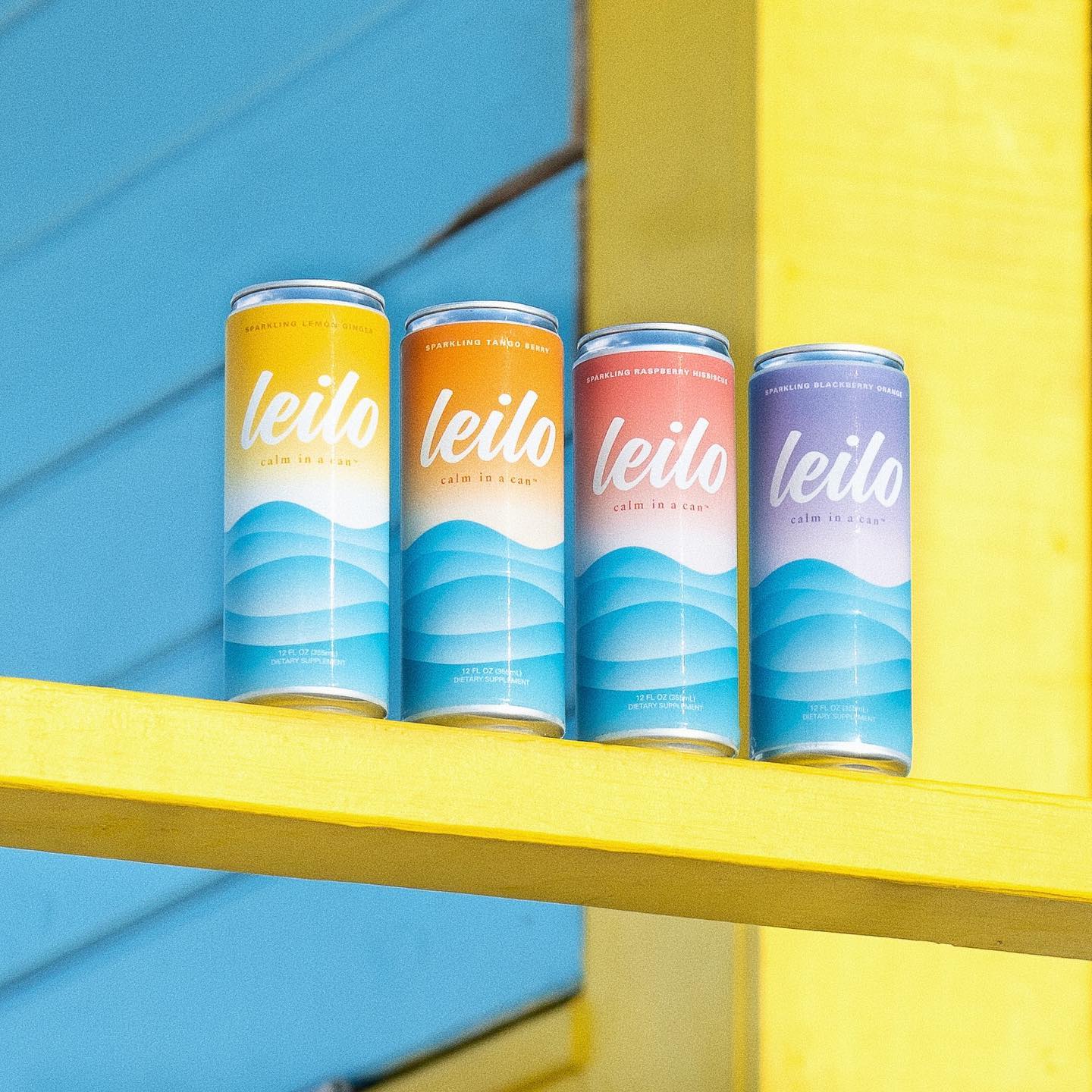 Leilo cans in a line on a yellow bar